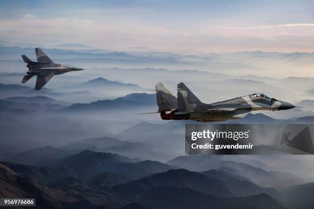 mig-29 fighter jets in flight above the fogy mountains - russian fighter plane stock pictures, royalty-free photos & images
