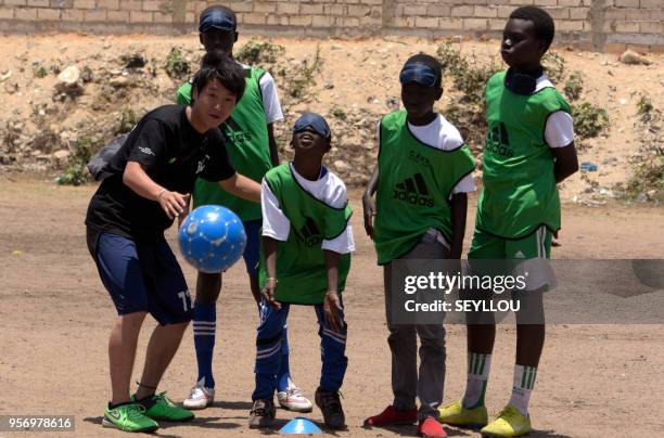 Volunteer Kouhei Kurihara teaches children blind football at the CFPT Center for Technical and Vocational Training Senegal Japan, during the national...