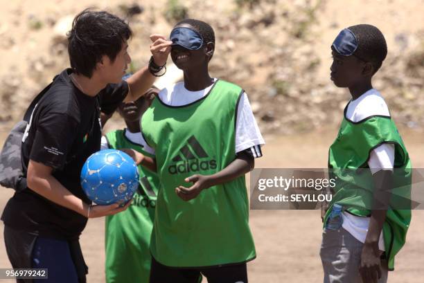 Volunteer Kouhei Kurihara teaches children blind football at the CFPT Center for Technical and Vocational Training Senegal Japan, during the national...