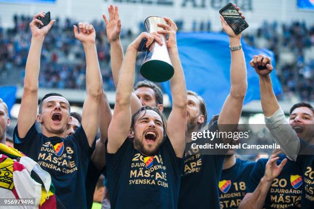 Kevin Walker of Djurgardens IF raises the Swedish Cup as his teammates celebrate winning the Svenska Cupen Final between Djurgardens IF and Malmo FF...