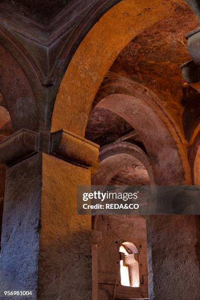 The rock-hewn churches of Lalibela in Ethiopia. Pilgrim praying in front of a church. The churches of Lalibela have been constructed in the 12th or...