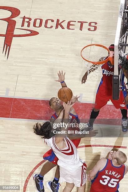 Luis Scola of the Houston Rockets lays up a shot against Marcus Camby and Chris Kaman of the Los Angeles Clippers during the game on December 22,...