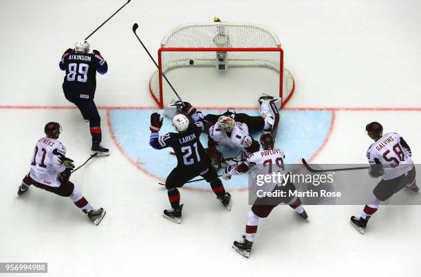 Cam Atkinson of United States scores the game winning goal in over time over Elvis Merzlikins, goaltender of Latvia during the 2018 IIHF Ice Hockey...