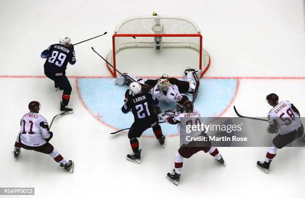 Cam Atkinson of United States scores the game winning goal in over time over Elvis Merzlikins, goaltender of Latvia during the 2018 IIHF Ice Hockey...