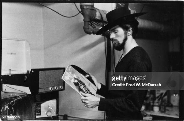 American beat poet and manager of Cafe Rafio Ronald Von Ehmsen removes a record from its sleeve as he stands in his basement apartment , New York,...