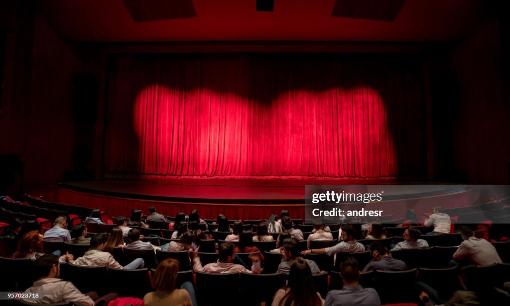 Audiencia ansiosa esperando las cortinas abrir para ver el funcionamiento