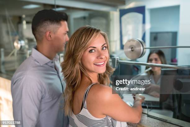 beautiful woman looking at camera standing next to her partner at the box office ready to watch a movie - balcão da bilheteira imagens e fotografias de stock