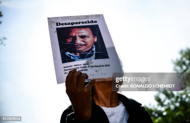 Demonstrator holds a portrait of a missing relative, during a march to demand the Mexican government answers about their loved ones whereabouts, as...