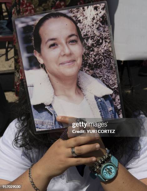 Demonstrator holds a portrait of a missing relative, during a march to demand the Mexican government answers about their loved ones whereabouts, as...