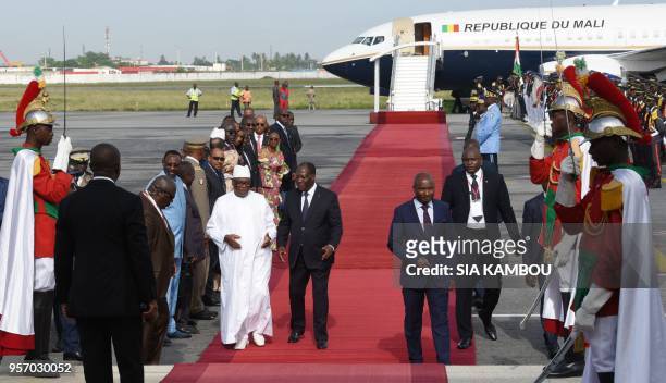 Ivory Coast President Alassane Ouattara stands with Malian President Ibrahim Boubacar Keita as they inspect a guard of honour after Keita's arrival...