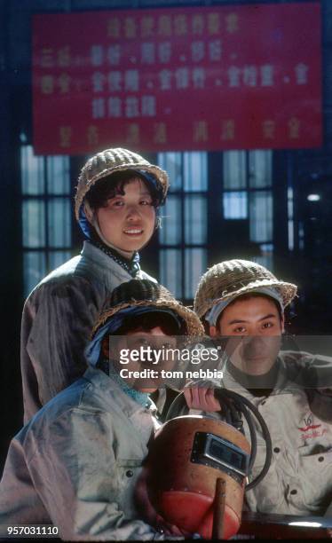 Portrait of three shipyard welders as they pose with some of their gear, Shanghai, China, April 1980.