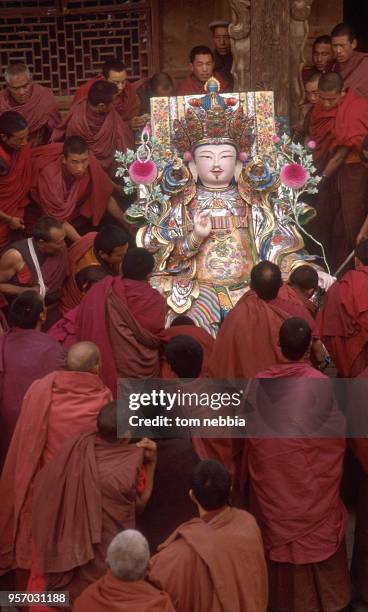 Elevated view of a group of monks as they lift a large statue of Buddha, sculpted from yak butter, at the Ta'er lamasery, Xining, Qinghai province,...