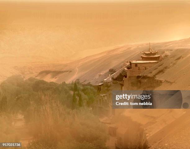 View of buildings, including entrance to the Mogao Caves , and the landscape beyond, obscured by a dust storm, Dunhuang, Gansu province, China, April...