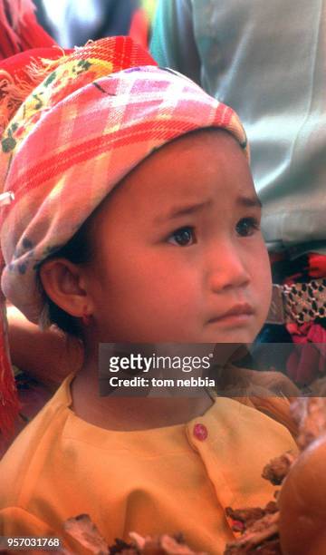 Close-up of a Dai child in brightly colored clothing, Xishuangbanna, Yunnan province, China, April 1980.