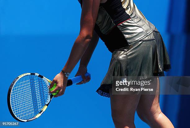Aravane Rezai of France, wearing a gold dress, prepares to serve in her second round match against Agnes Szavay of Hungary during day three of the...