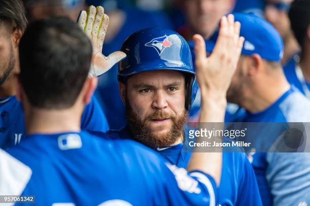 Russell Martin of the Toronto Blue Jays celebrates in the dugout after hitting a two-run home run during the second inning against the Cleveland...