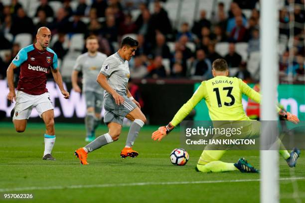 Manchester United's Chilean striker Alexis Sanchez runs the ball around West Ham United's Spanish goalkeeper Adrian , but fails to score during the...