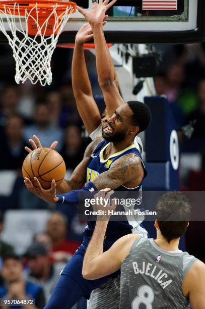 Will Barton of the Denver Nuggets shoots the ball against Taj Gibson and Nemanja Bjelica of the Minnesota Timberwolves during the game on April 11,...