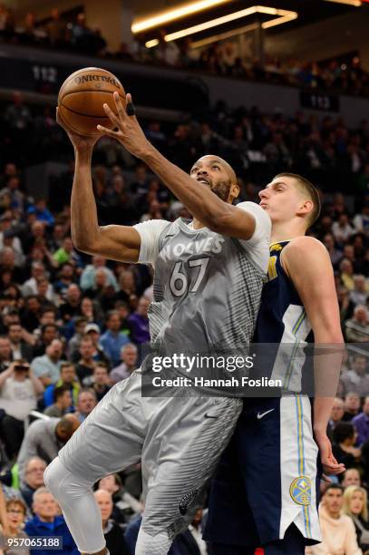 Taj Gibson of the Minnesota Timberwolves shoots the ball against Nikola Jokic of the Denver Nuggets during the game on April 11, 2018 at the Target...
