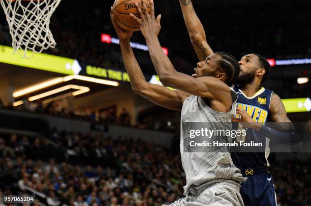 Andrew Wiggins of the Minnesota Timberwolves shoots the ball against Will Barton of the Denver Nuggets during the game on April 11, 2018 at the...