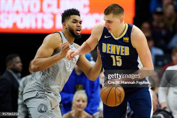 Karl-Anthony Towns of the Minnesota Timberwolves defends against Nikola Jokic of the Denver Nuggets during the game on April 11, 2018 at the Target...