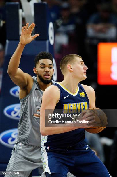 Karl-Anthony Towns of the Minnesota Timberwolves defends against Nikola Jokic of the Denver Nuggets during the game on April 11, 2018 at the Target...