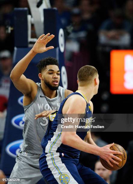 Karl-Anthony Towns of the Minnesota Timberwolves defends against Nikola Jokic of the Denver Nuggets during the game on April 11, 2018 at the Target...