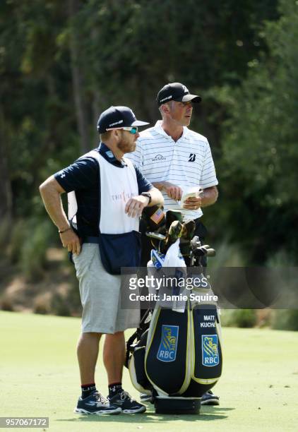 Matt Kuchar of the United States and caddie John Wood prepare to play a shot on the tenth hole during the first round of THE PLAYERS Championship on...