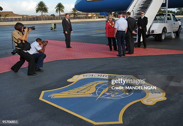 Secretary of State Hillary Clinton chats with base personnel January 11, 2010 upon arrival at Hickam Air Force Base in Honolulu. Clinton arrived in...