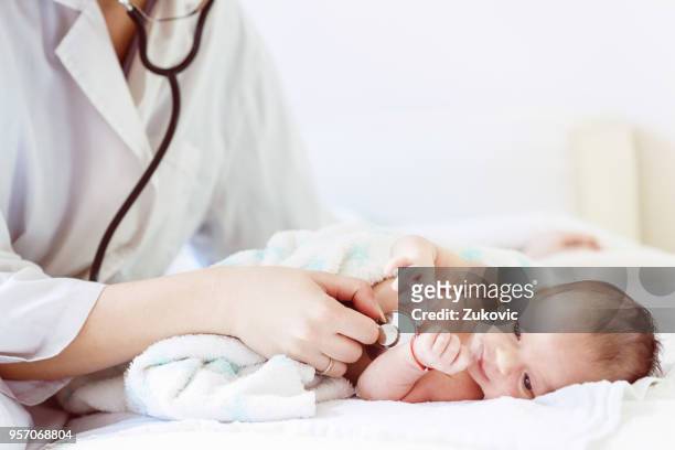 ärztin untersucht säugling mit stethoskop - stethoscope heart stock-fotos und bilder