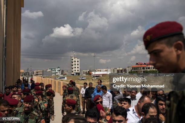 Members of the Iraqi security forces queue up to collect their ballot papers during early voting for Iraq's parliamentary elections on May 10, 2018...