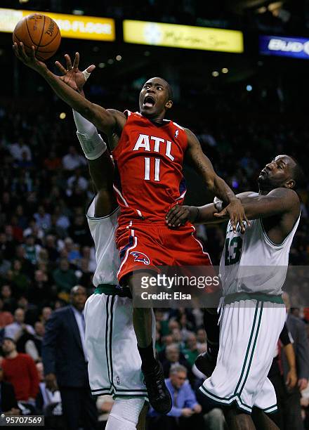 Jamal Crawford of the Atlanta Hawks goes up for two past Ray Allen and Kendrick Perkins of the Boston Celtics at the TD Garden on January 11, 2010 in...