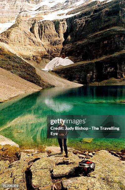 woman hiker pausing at green mountain lake - lago o'hara foto e immagini stock