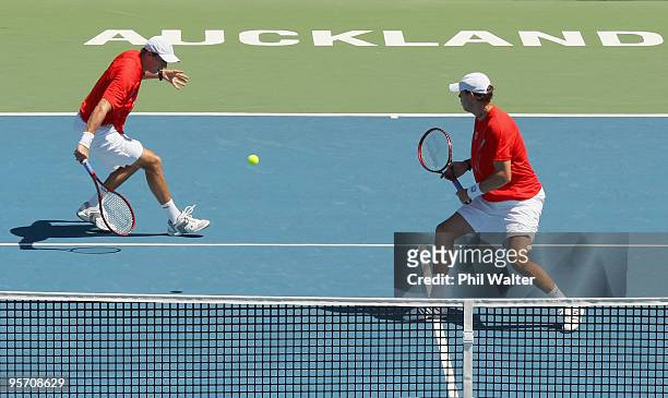 Mike Bryan of the USA plays a backhand with support from Bob Bryan of the USA during their first round doubles match against Horacio Zeballos of...