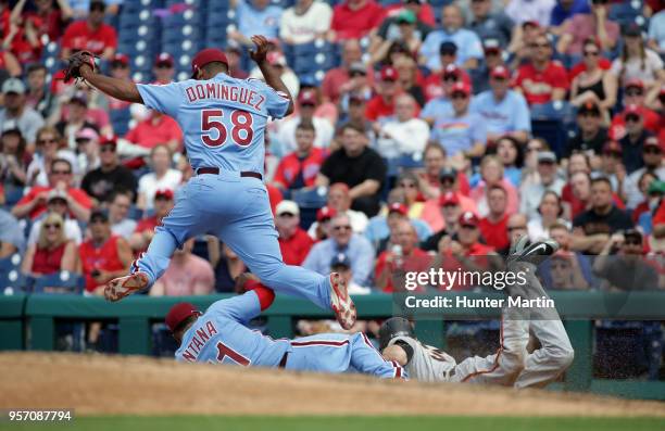 Carlos Santana of the Philadelphia Phillies fields a ground ball and beats Kelby Tomlinson of the San Francisco Giants to the first base bag for an...