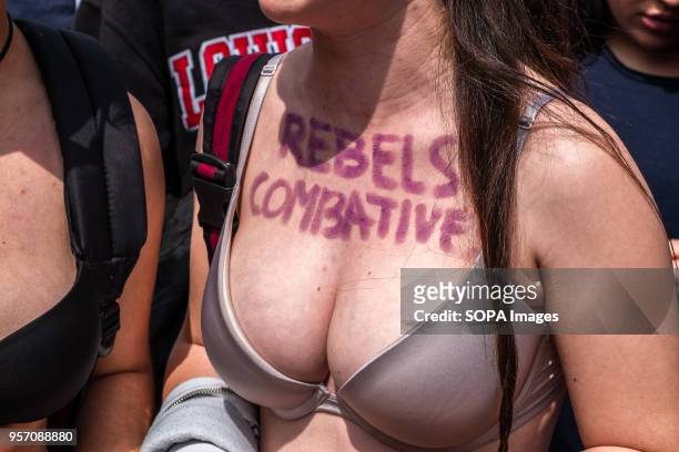 Young girl is seen in bra with her chest painted with the text "Rebels and combatives". Under the slogan "it's not abuse, it's rape" more than 5,000...