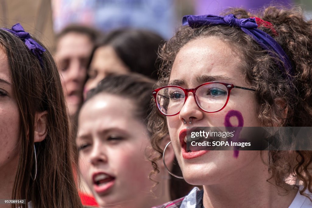 A young woman is seen screaming slogans with the sign of the...