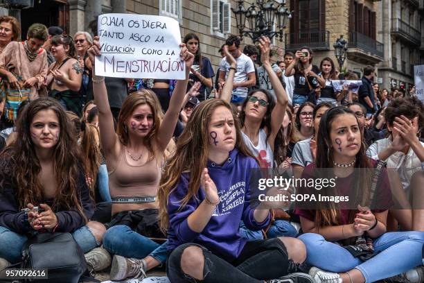 Group of women are seen sitting on the floor with a sign with the text "I wish the rape would give you as much disgust as menstruation". Under the...