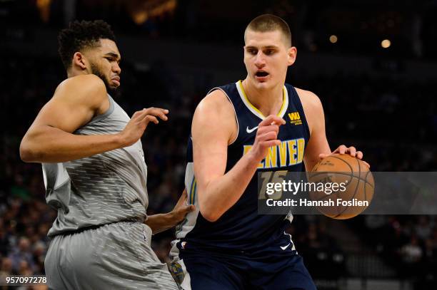 Karl-Anthony Towns of the Minnesota Timberwolves defends against Nikola Jokic of the Denver Nuggets during the game on April 11, 2018 at the Target...