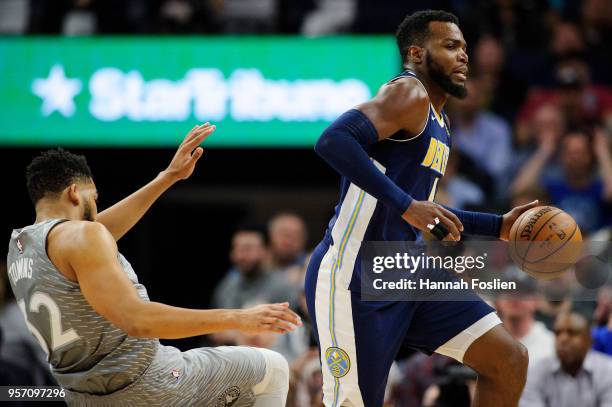 Karl-Anthony Towns of the Minnesota Timberwolves defends against Paul Millsap of the Denver Nuggets during the game on April 11, 2018 at the Target...