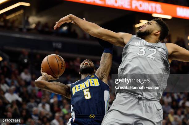 Karl-Anthony Towns of the Minnesota Timberwolves fouls Will Barton of the Denver Nuggets while shooting the ball during the game on April 11, 2018 at...