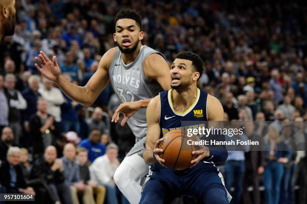 Jamal Murray of the Denver Nuggets shoots the ball against Karl-Anthony Towns of the Minnesota Timberwolves during the game on April 11, 2018 at the...