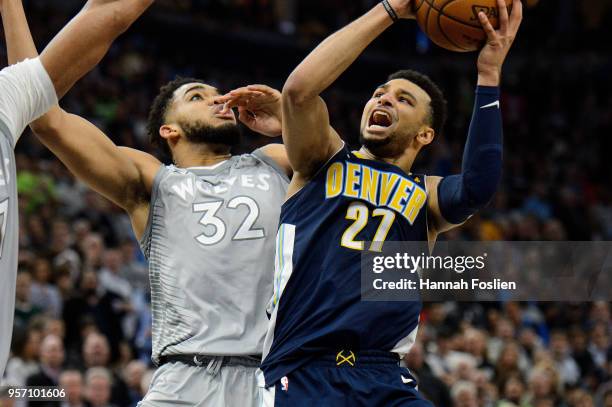 Jamal Murray of the Denver Nuggets shoots the ball against Karl-Anthony Towns of the Minnesota Timberwolves during the game on April 11, 2018 at the...