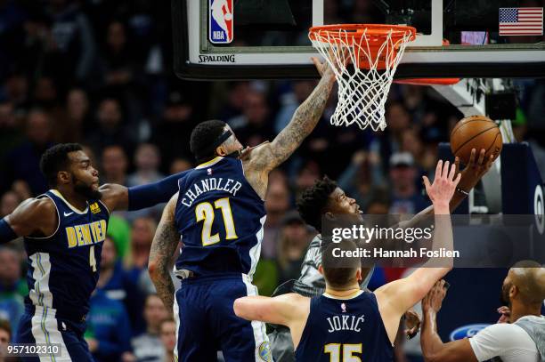 Jimmy Butler of the Minnesota Timberwolves shoots the ball against Paul Millsap, Wilson Chandler and Nikola Jokic of the Denver Nuggets during the...