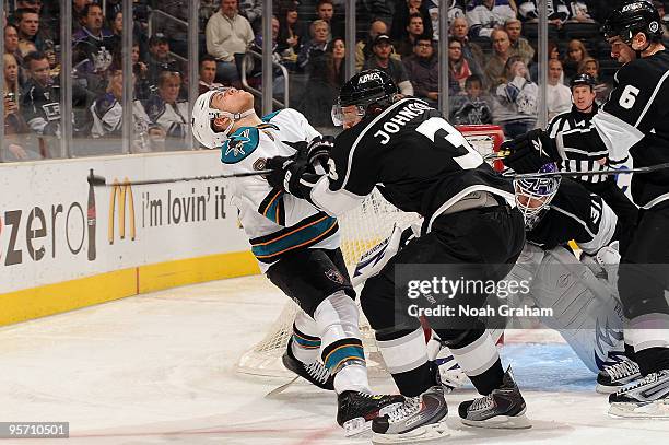 Joe Pavelski of the San Jose Sharks takes a hit from Jack Johnson of the Los Angeles Kings during the game on January 11, 2010 at Staples Center in...