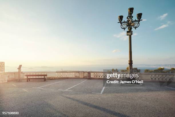 empty carpark with direct sun light overlooking the sea - parking lot stock pictures, royalty-free photos & images