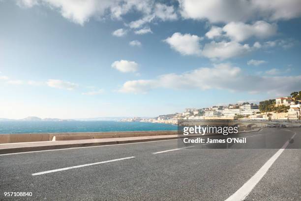 empty curved road with background sea and city - road city bildbanksfoton och bilder