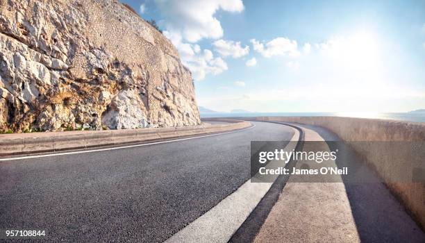 empty curved coastal road on sunny day - autoroute france stock pictures, royalty-free photos & images