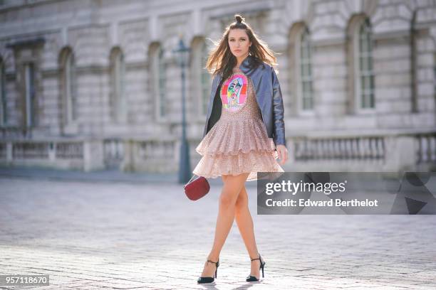 Landiana Cerciu wears a leather jacket, a ruffled pink dress with lace, a red bag during London Fashion Week February 2018 on February 16, 2018 in...