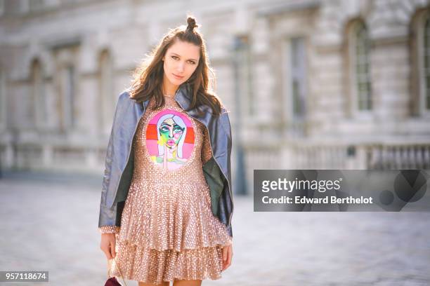 Landiana Cerciu wears a leather jacket, a ruffled pink dress with lace, a red bag during London Fashion Week February 2018 on February 16, 2018 in...